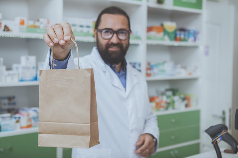 Pharmacist with bag of painkillers for knee pain